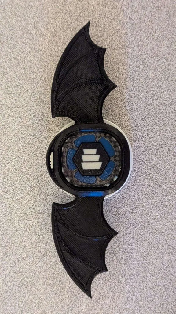 A smart watch cover laid on top of a poker chip printed on the J55
